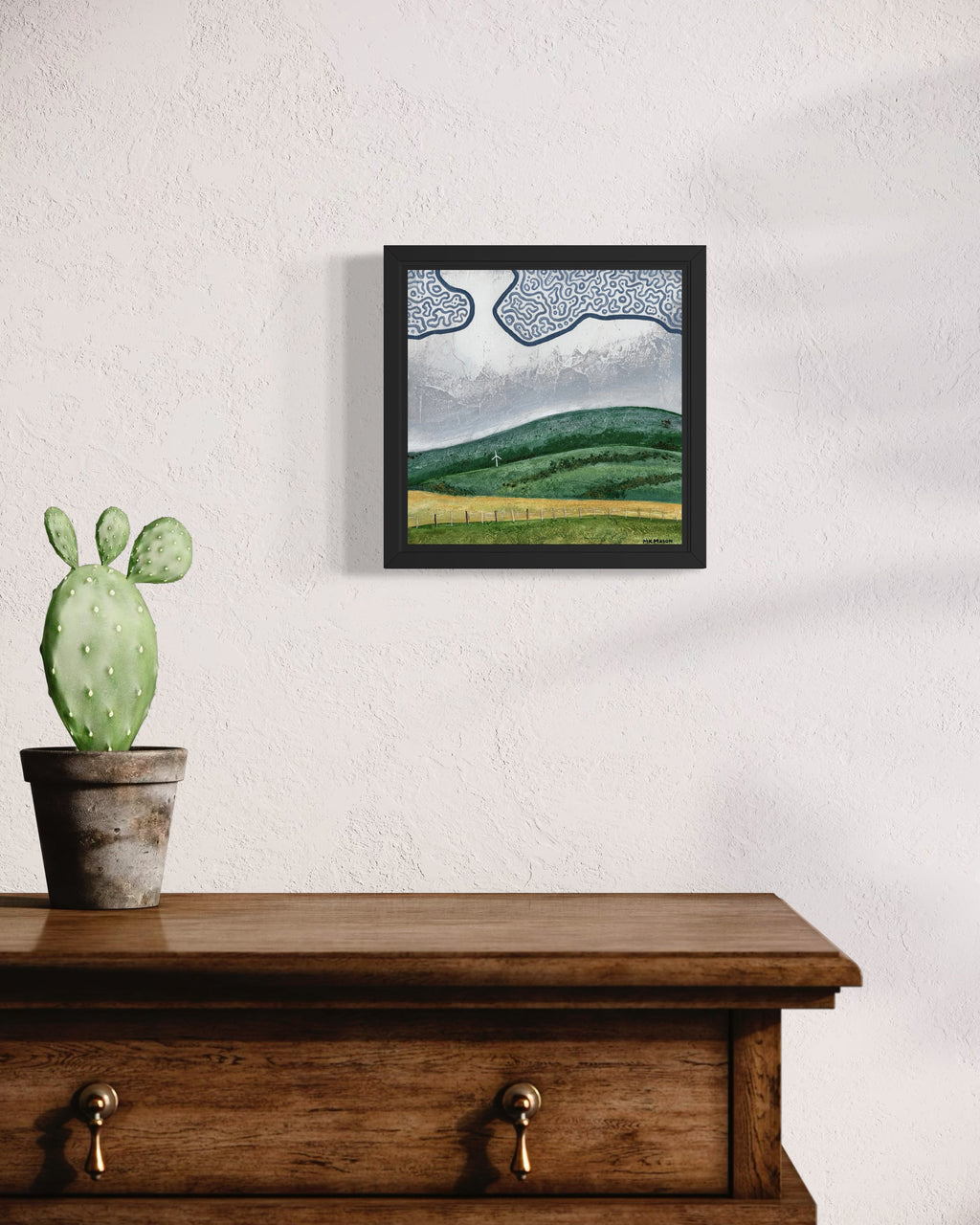 Acrylic landscape painting of rolling green hills with a small windmill and textured gray sky with abstract clouds, created by MK Mason, interior mockup